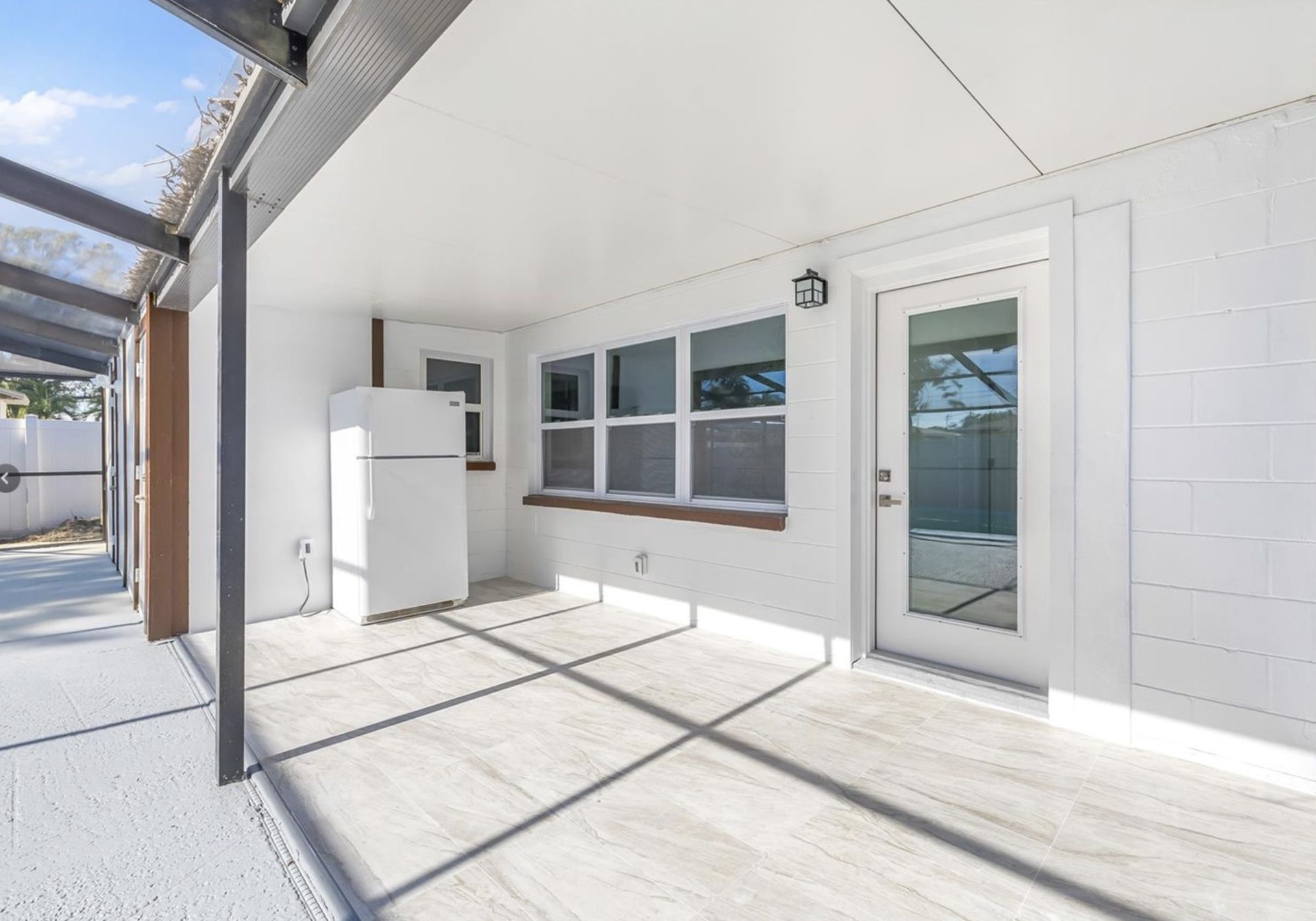 There is a refrigerator in the backyard of a house.