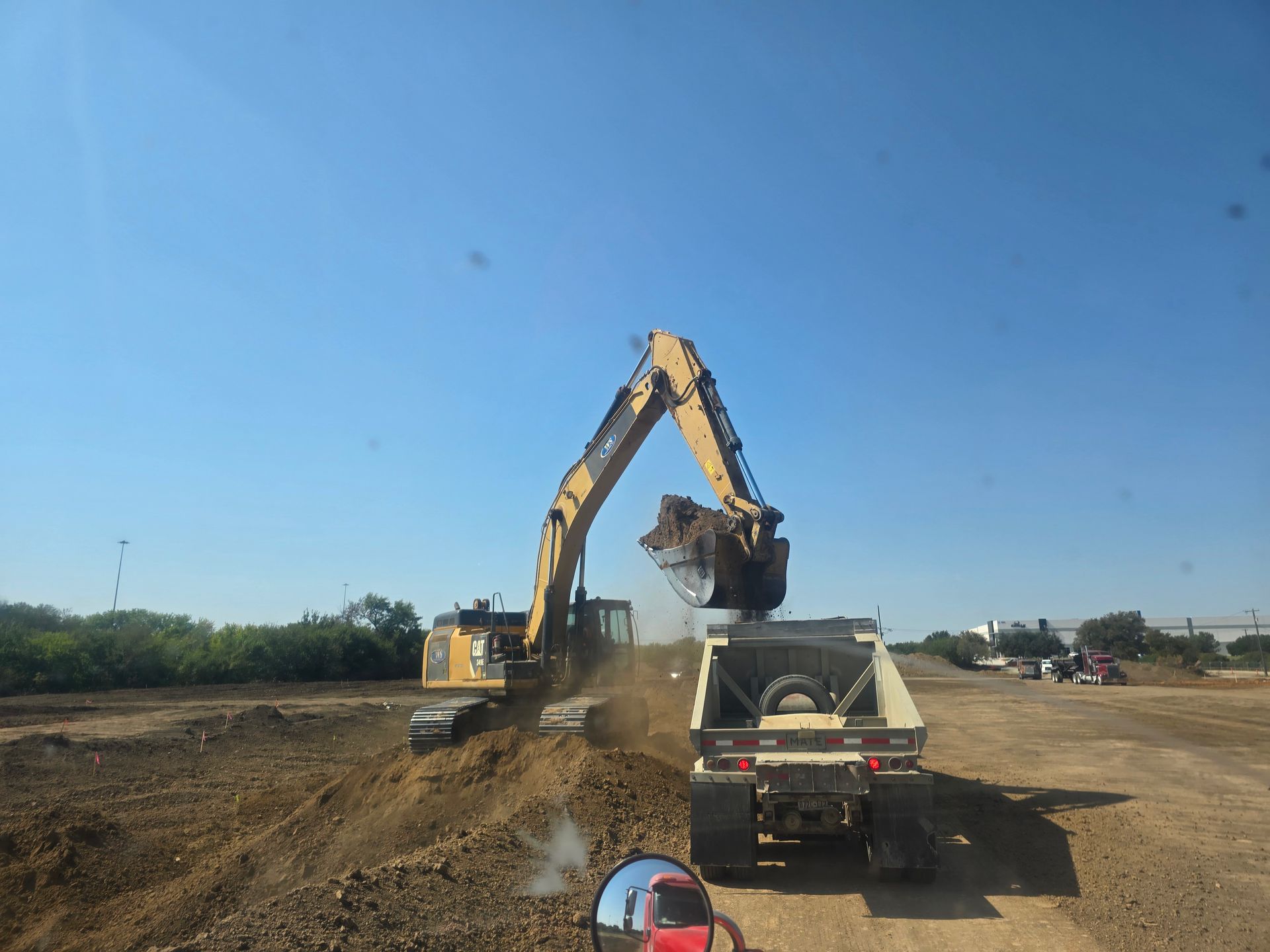 An excavator is loading dirt into a dump truck