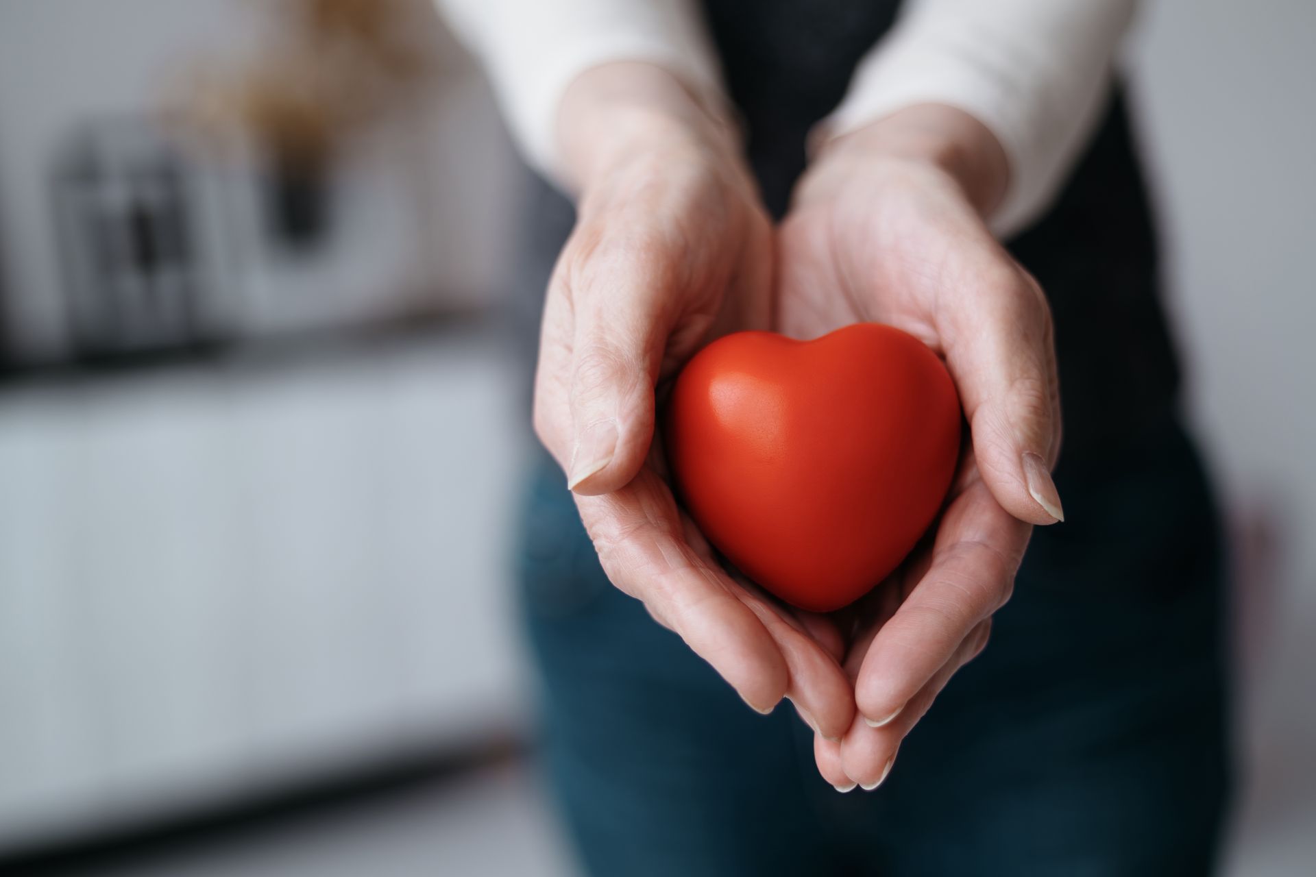 A woman and child are holding a heart made of puzzle pieces in their hands.