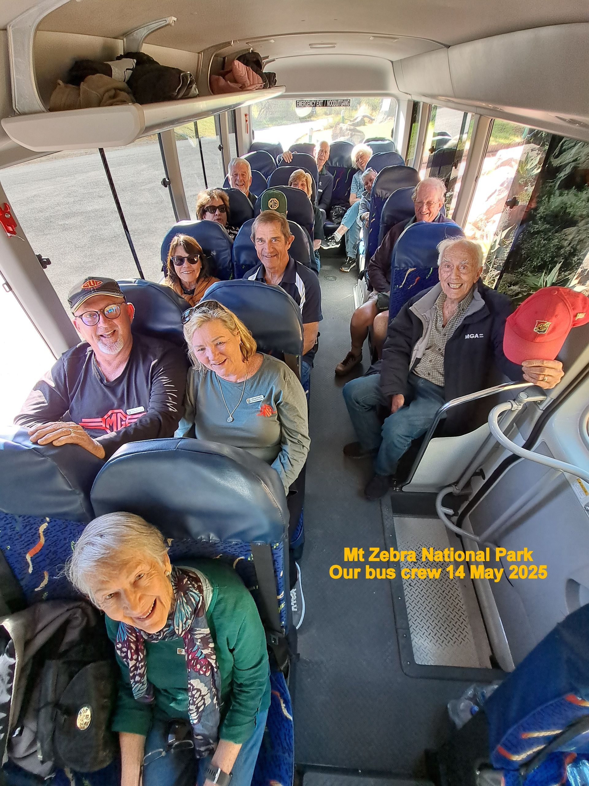 Group of people on a bus tour in Zion National Park. They are smiling and looking at the camera.