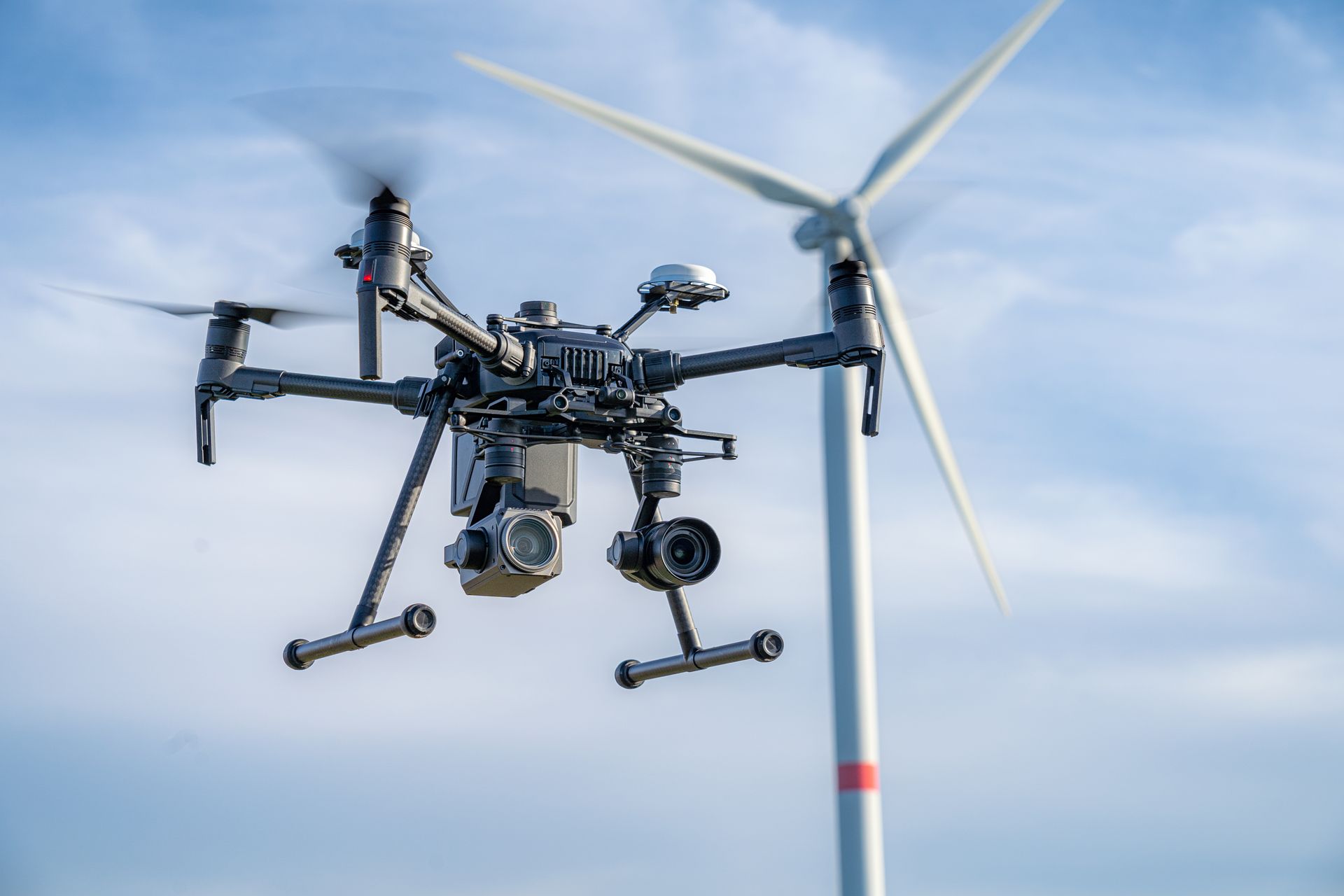 Black drone in flight, inspecting a wind turbine against a blue sky — Jetstream Aerial Services in Te Kowai, QLD