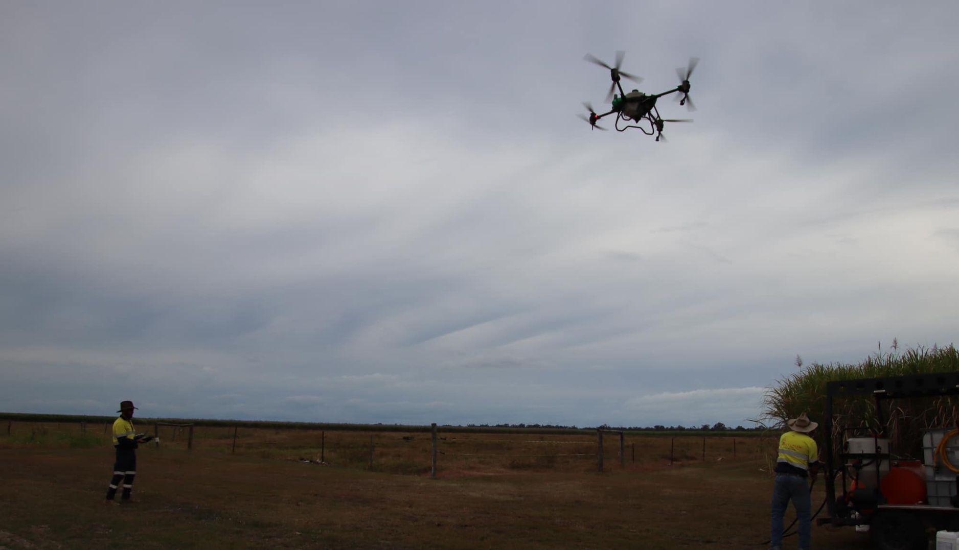 Drone in Flight, Controlled by Two People in A Field Under a Cloudy Sky — Jetstream Aerial Services in Te Kowai, QLD