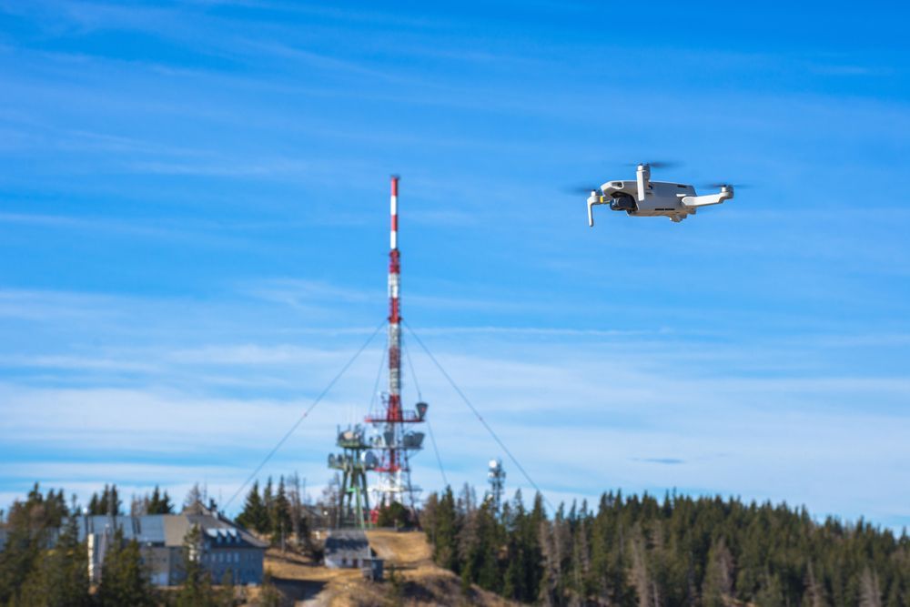 Drone Flying Near a Communication Tower on A Hillside Under a Blue Sky — Jetstream Aerial Services in Te Kowai, QLD