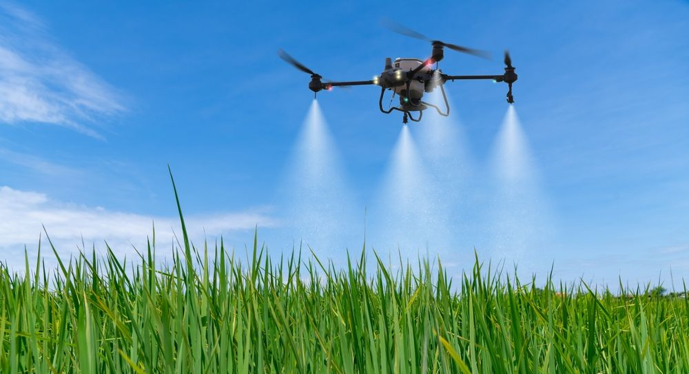 Drone Spraying a Field of Green Crops Under a Bright Blue Sky — Jetstream Aerial Services in Te Kowai, QLD