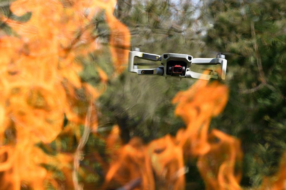 Drone Flying in Front of Orange Flames and Green Foliage — Jetstream Aerial Services in Te Kowai, QLD