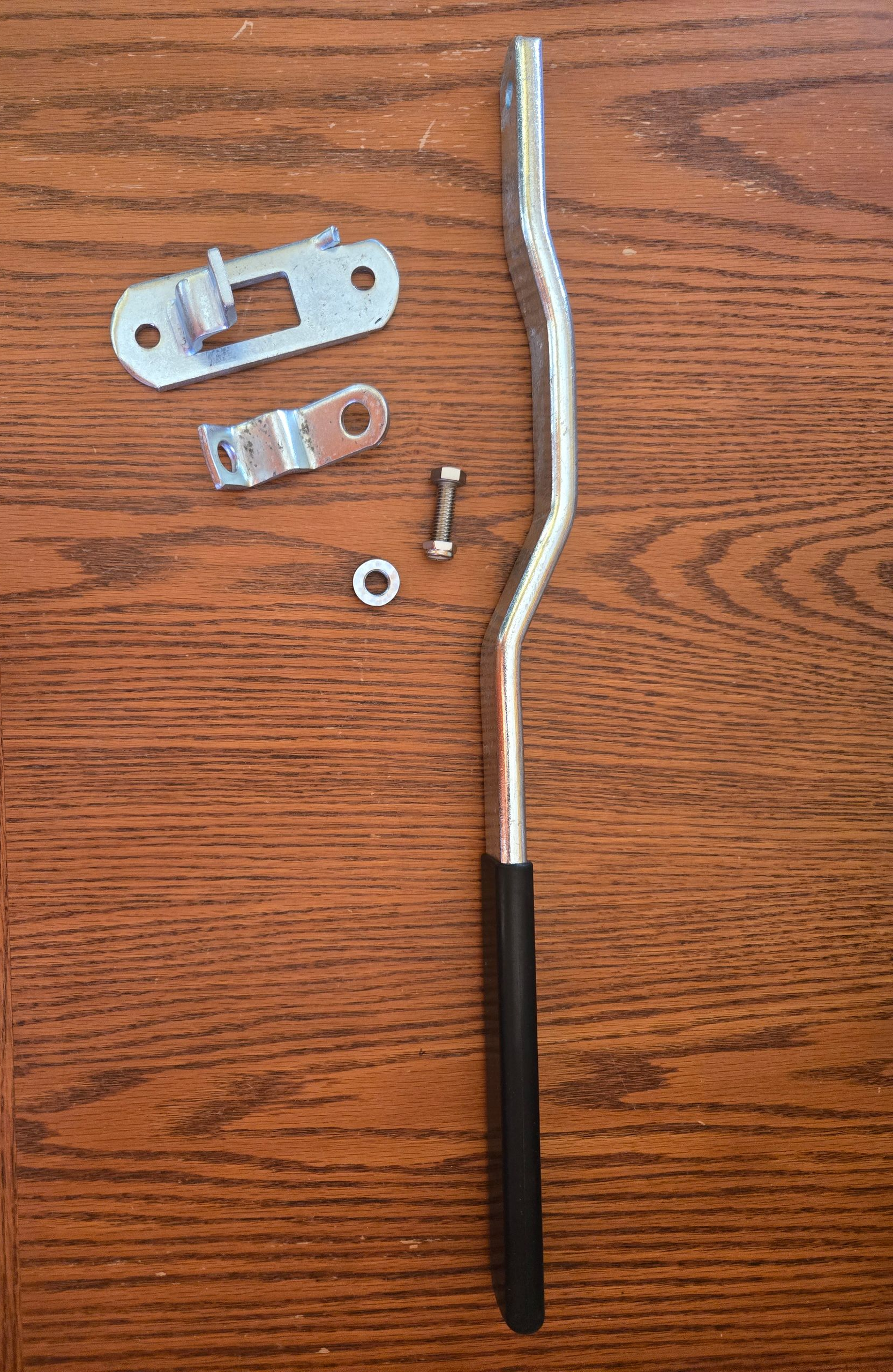 Two metal car brake tools with black handles on a brown surface.