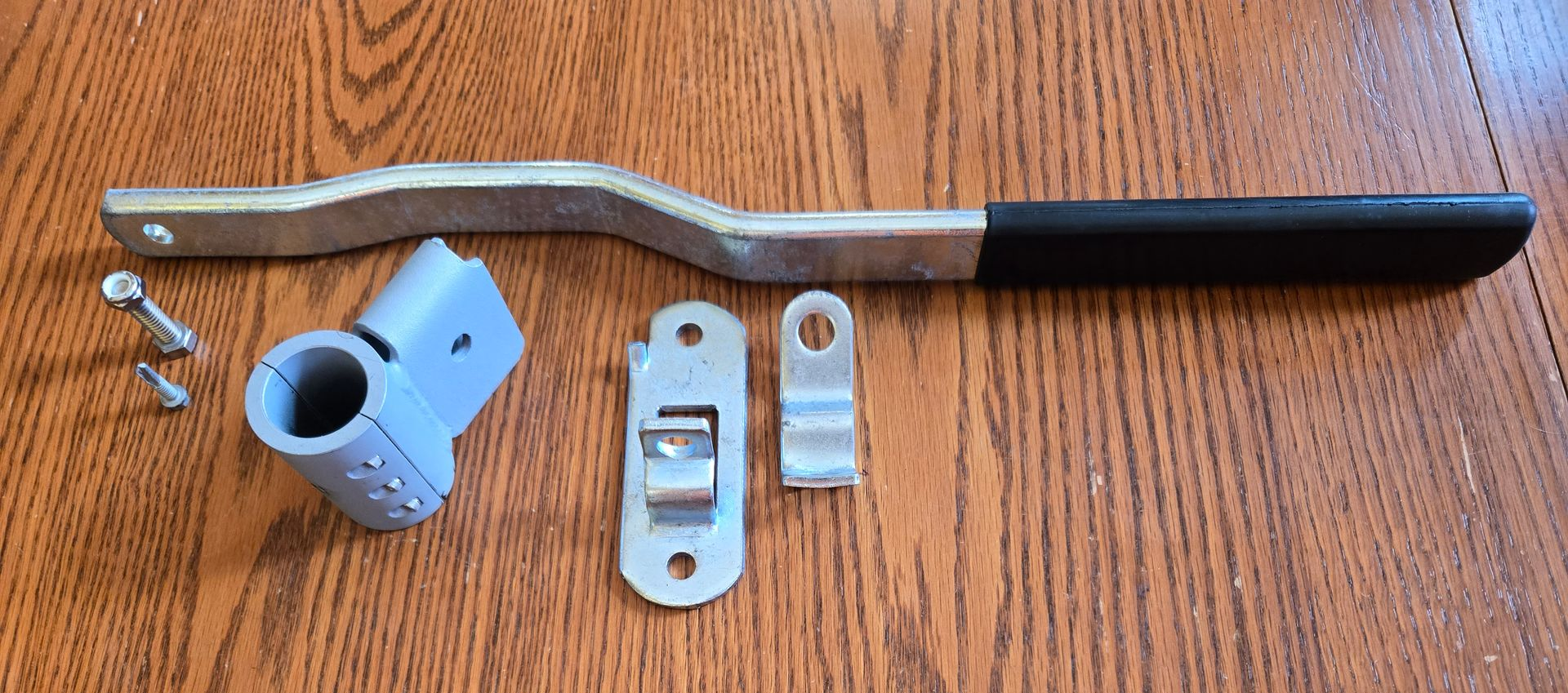 Two metal tools with black handles, lying on a brown surface. One tool has a toothed head.