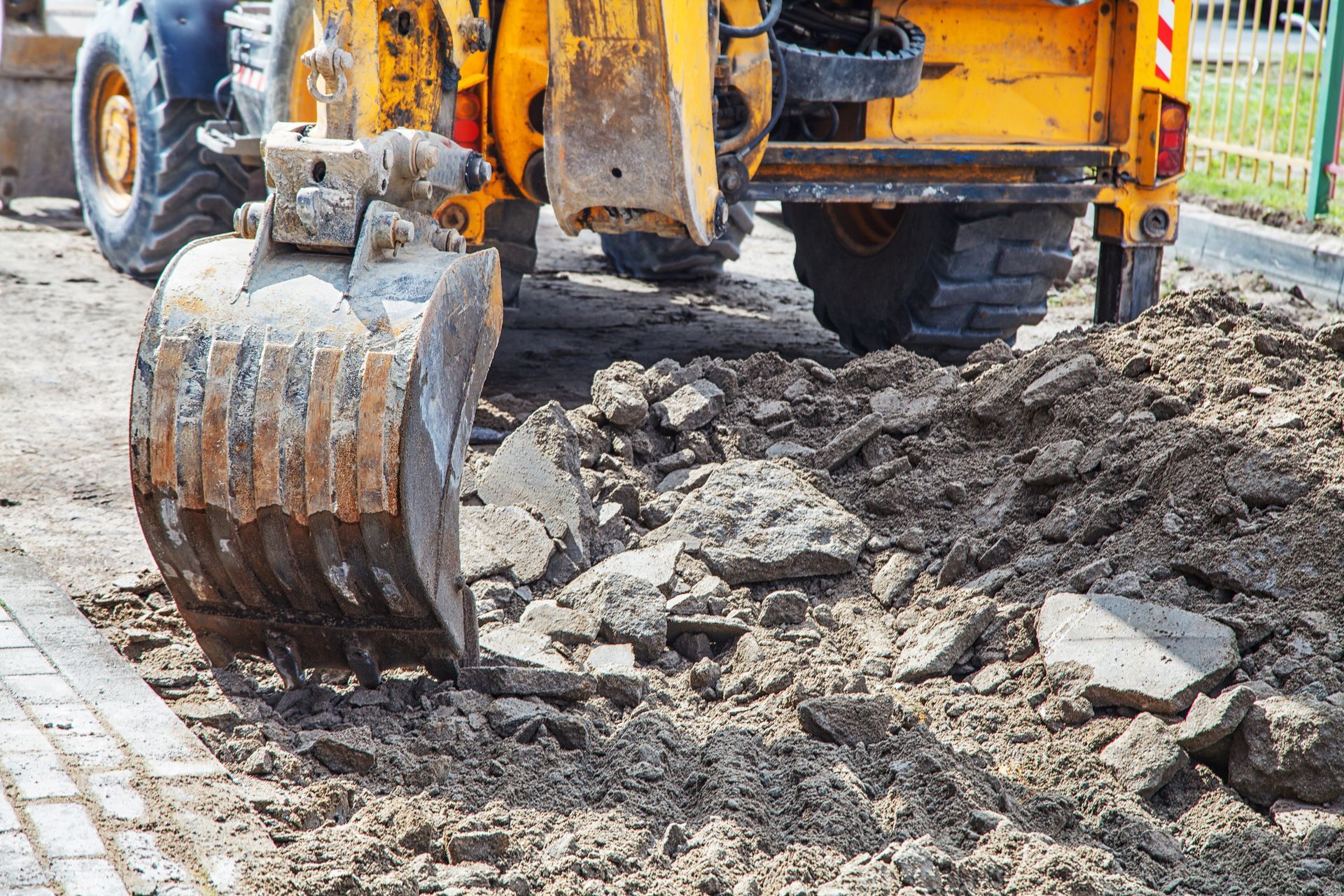 Excavator on site showcasing heavy equipment rental, preparing new road surface for construction.