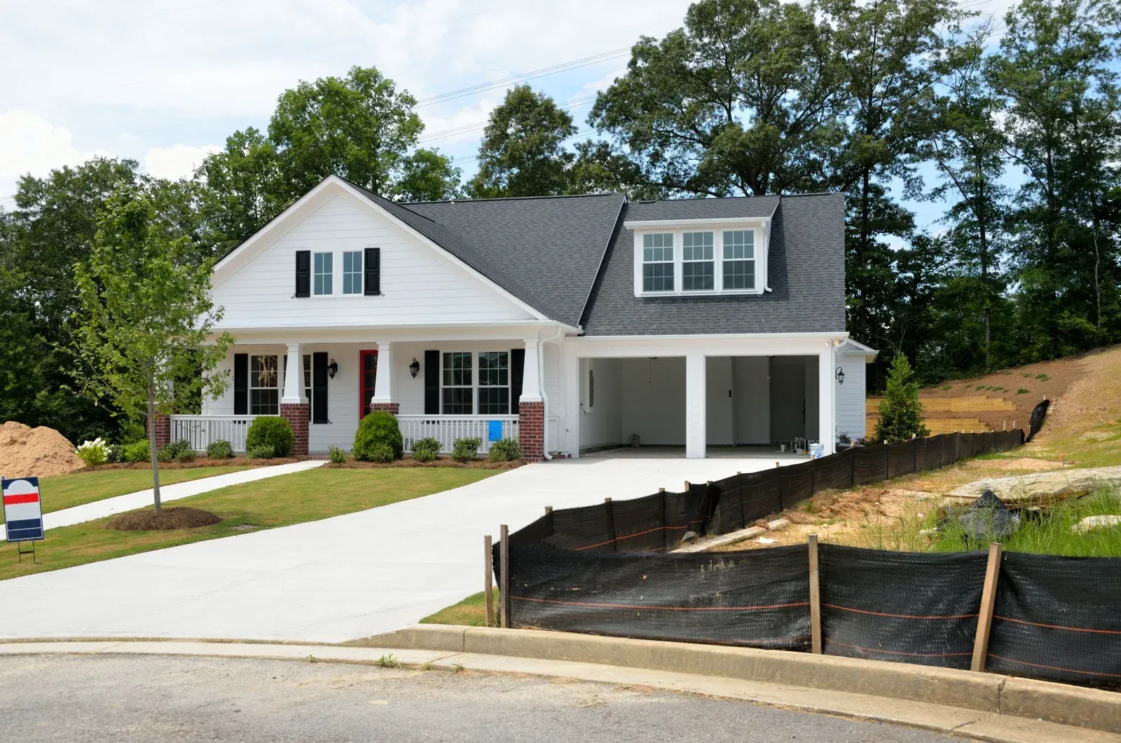 A large house with a lot of windows and a garage on a rainy day.