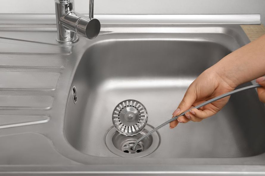 Professional drain cleaning service removing a clogged kitchen sink drain in Los Angeles