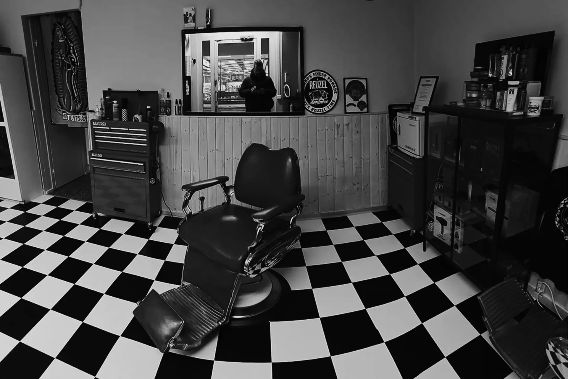 A black and white photo of a barber shop with a checkered floor