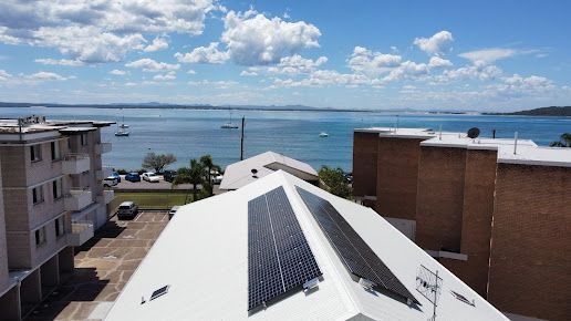 Solar panel on a red roof reflecting the sun — Level 2 Electrician in Newcastle NSW