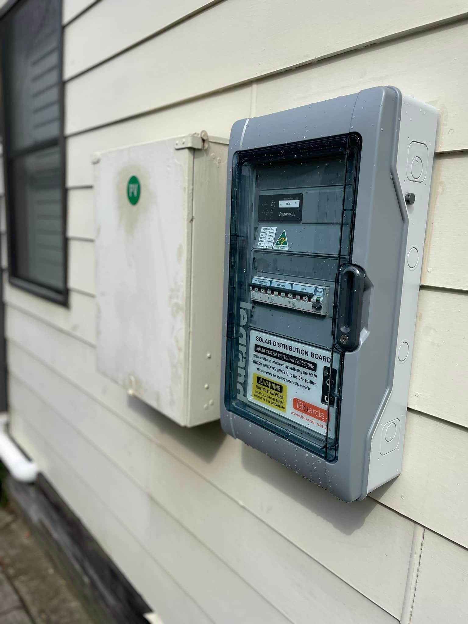 A Electrical Box Is Hanging On The Side Of A House — PRO Solar & Electrical In Lake Macquarie, NSW