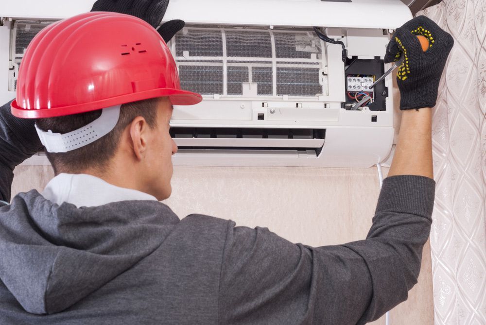 Electrician Servicing Air conditioning unit— Level 2 Electrician in Newcastle NSW