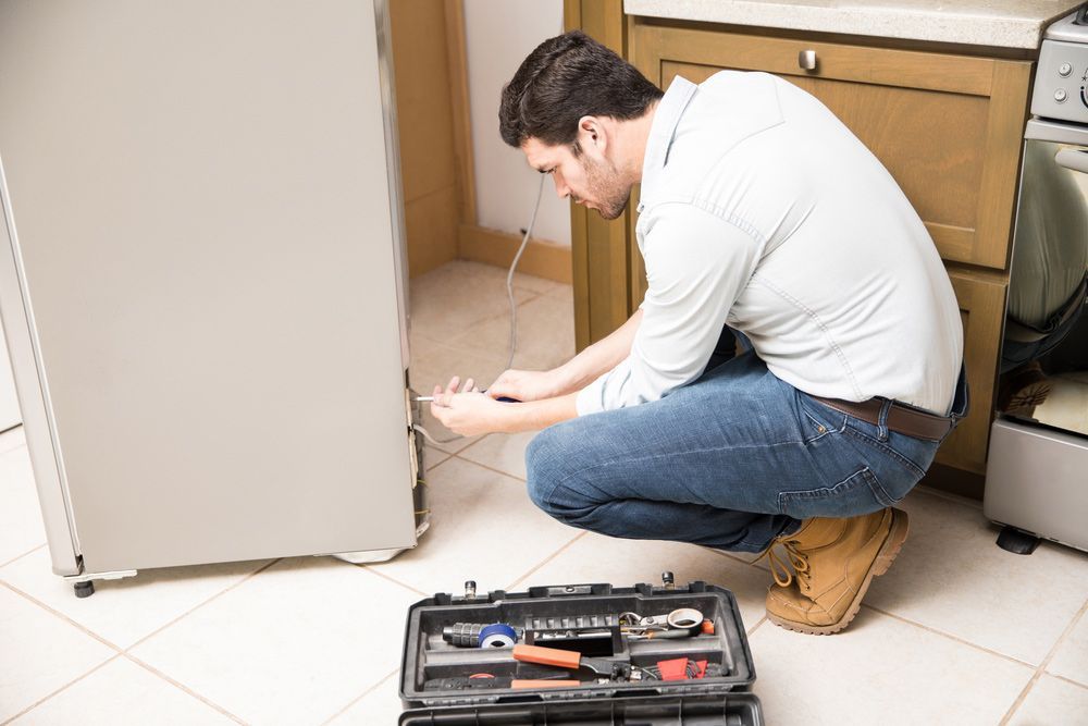 Electrician fixing a refrigerator — Level 2 Electrician in Newcastle NSW