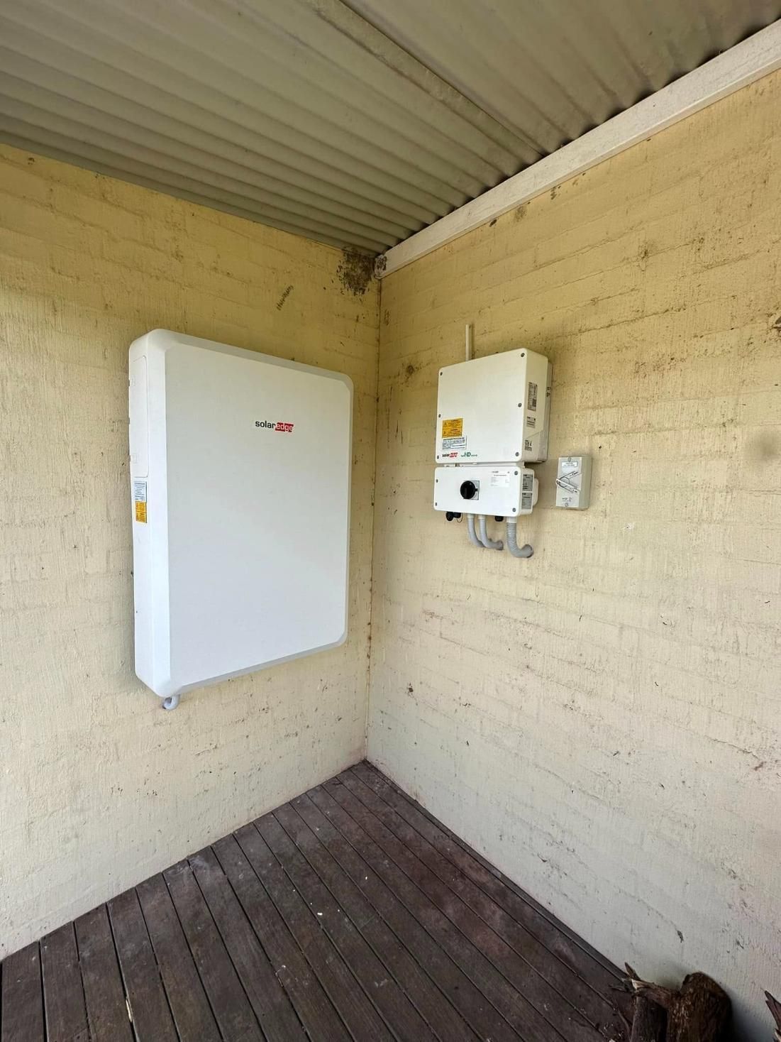 A White Box Is Hanging On A Brick Wall In A Room — PRO Solar & Electrical In Port Stephens, NSW