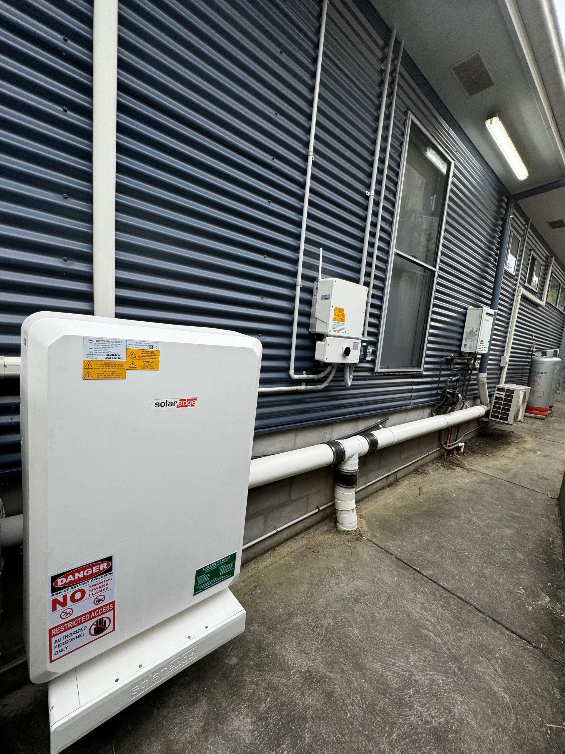 Battery Mounted On The Side Of A House — PRO Solar & Electrical In Maitland, NSW