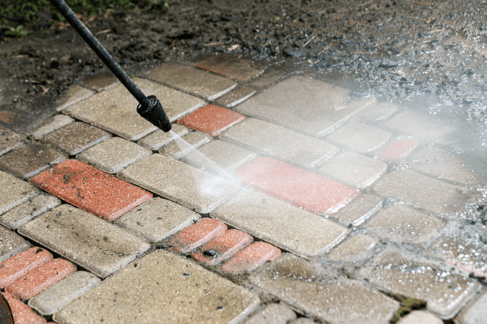Cracked concrete driveway in front of a two-car garage. The driveway shows significant cracking, with a house and lawn in the background.