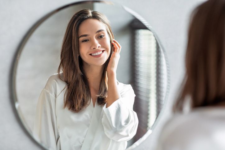 Attractive Happy Woman Looking At Mirror