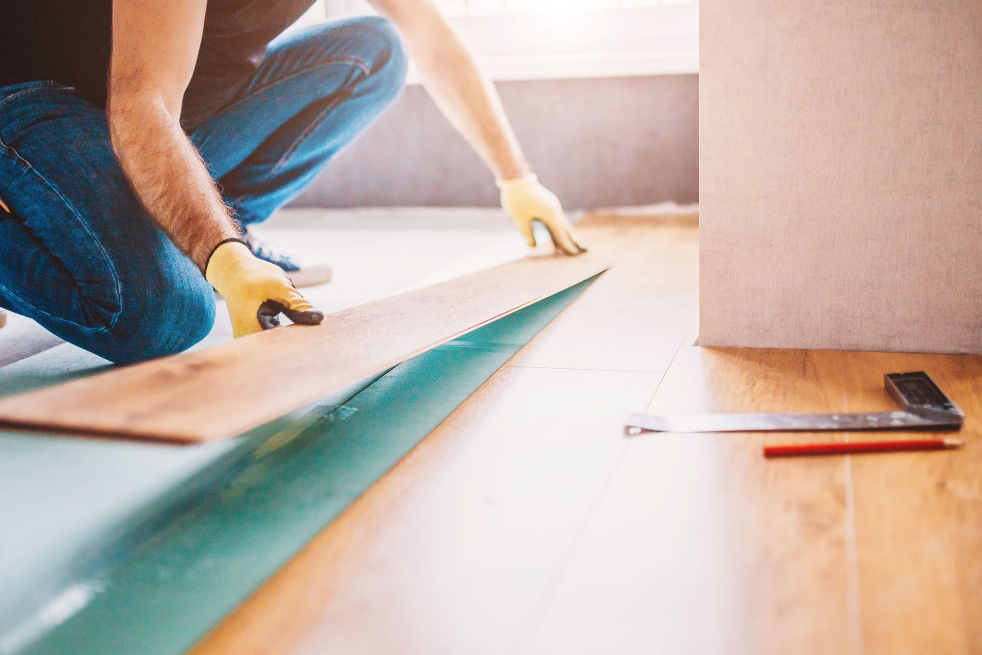 A Man Is Kneeling Down To Install A Wooden Floor