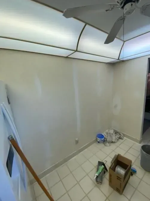 A room with a ceiling fan and a box on the floor