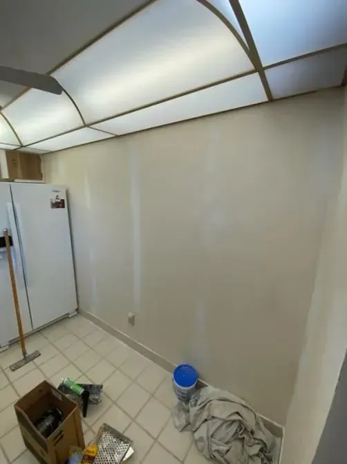 A room with a white refrigerator and a box on the floor