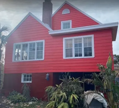 A large red house with white windows and a chimney