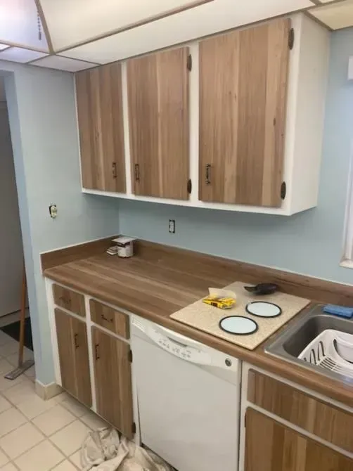 A kitchen with wooden cabinets and a white dishwasher