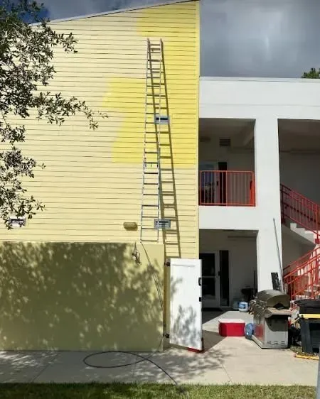 A yellow building with a ladder leaning against it