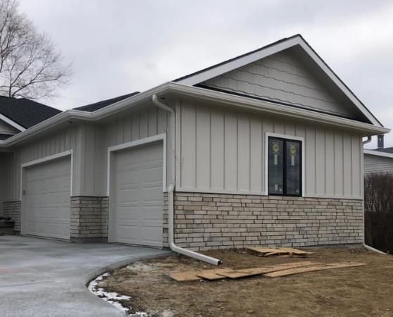 A house with a garage and a driveway in front of it.