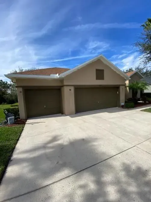 A house with two garage doors and a driveway in front of it.