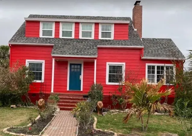 A red house with a blue door and white trim