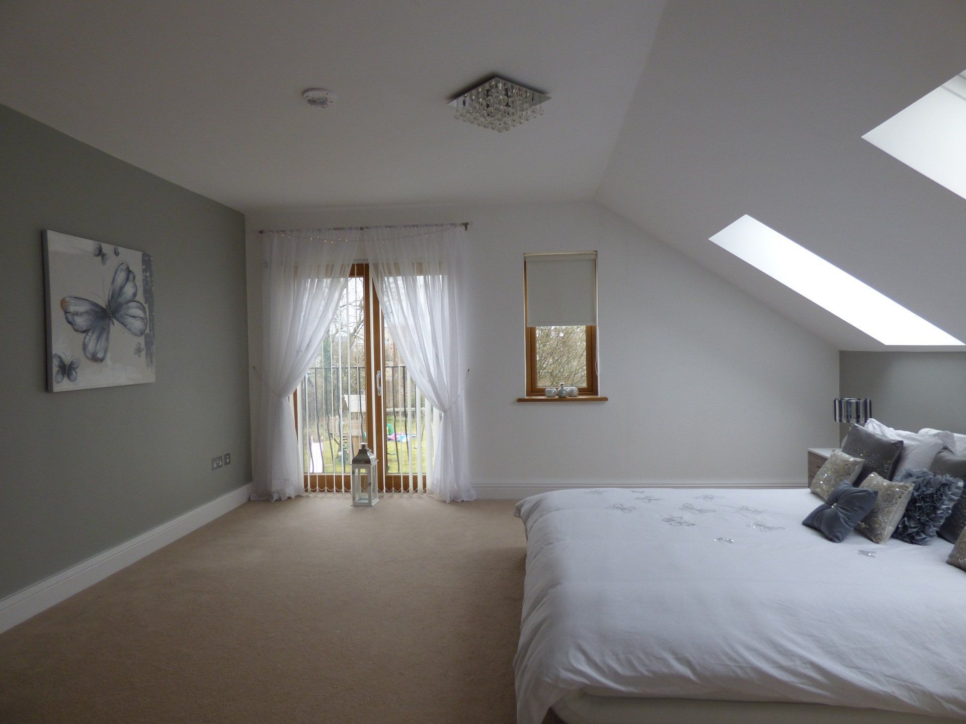 A bedroom with a bed , a window and a skylight.