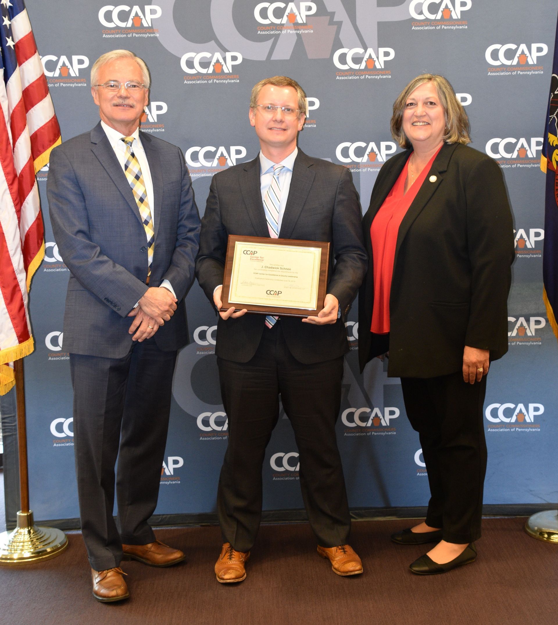 Three people standing in front of a wall that says cccap