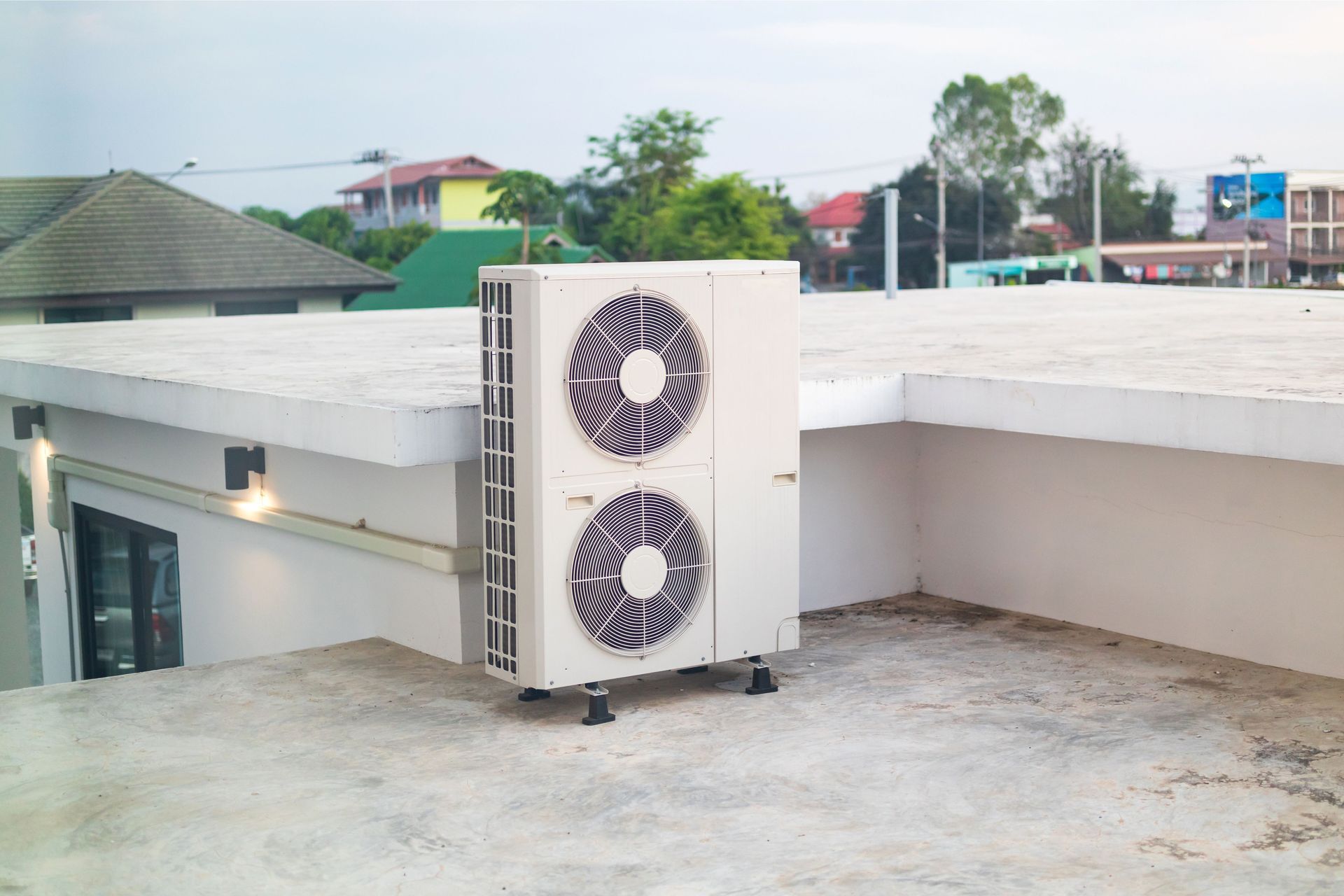 A large air conditioner is sitting on the roof of a building.