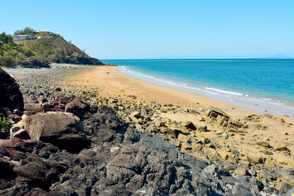 A Rocky Beach with A Large Body of Water in The Background — Paton's Electrical Services in K'Gari, QLD