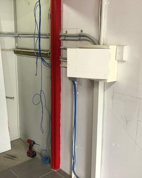 A Drill Is Sitting on The Floor Next to A Box with Wires Coming out Of It — Paton's Electrical Services in Torquay, QLD