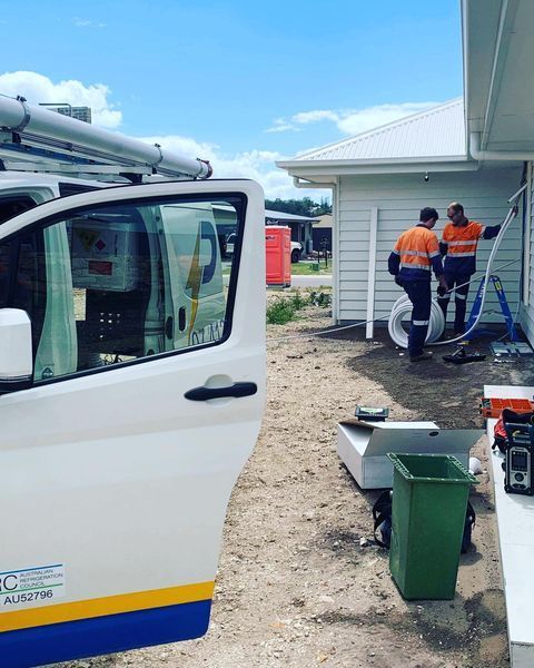 A White Van with The Door Open Is Parked in Front of A House — Paton's Electrical Services in K'Gari, QLD