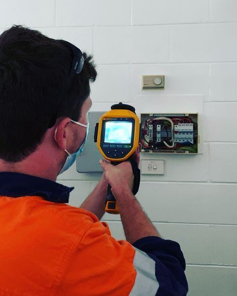A Man Wearing a Mask Is Using a Thermal Camera — Paton's Electrical Services in K'Gari, QLD