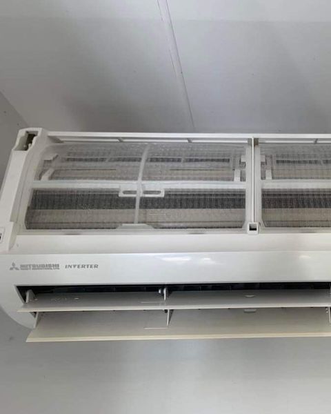 A White Air Conditioner Is Hanging from The Ceiling in A Room — Paton's Electrical Services in Urraween, QLD