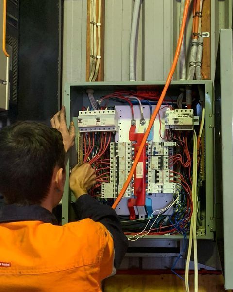 A Man Is Working on An Electrical Box — Paton's Electrical Services in Hervey Bay, QLD