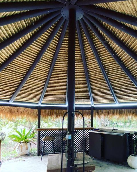 The Inside of A Gazebo with A Thatched Roof — Paton's Electrical Services in Urraween, QLD