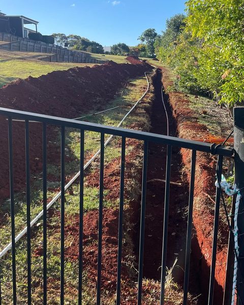 A Fence with A Hole in The Ground Behind It — Paton's Electrical Services in Urangan, QLD