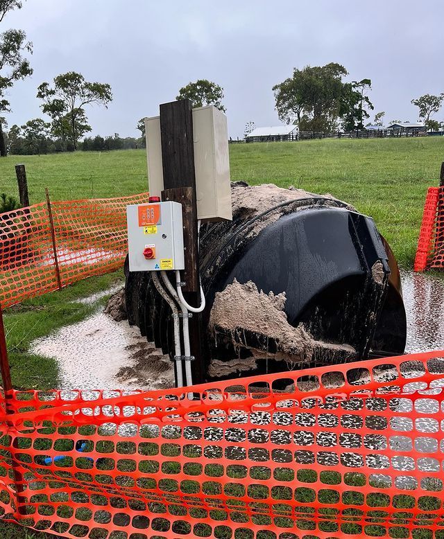 An Orange Fence Surrounds a Large Black Object in A Field — Paton's Electrical Services in K'Gari, QLD