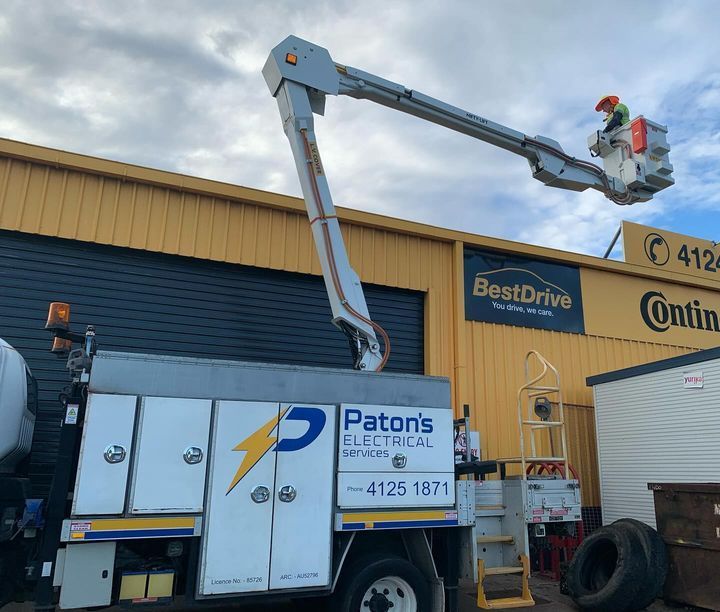 A Patons Electrical Truck Is Parked in Front of A Building — Paton's Electrical Services in Urangan, QLD