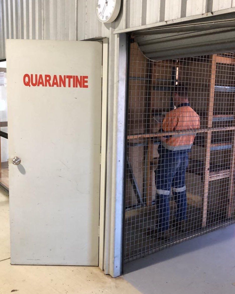 A Man Is Standing in Front of A Door that Says Quarantine — Paton's Electrical Services in Hervey Bay, QLD