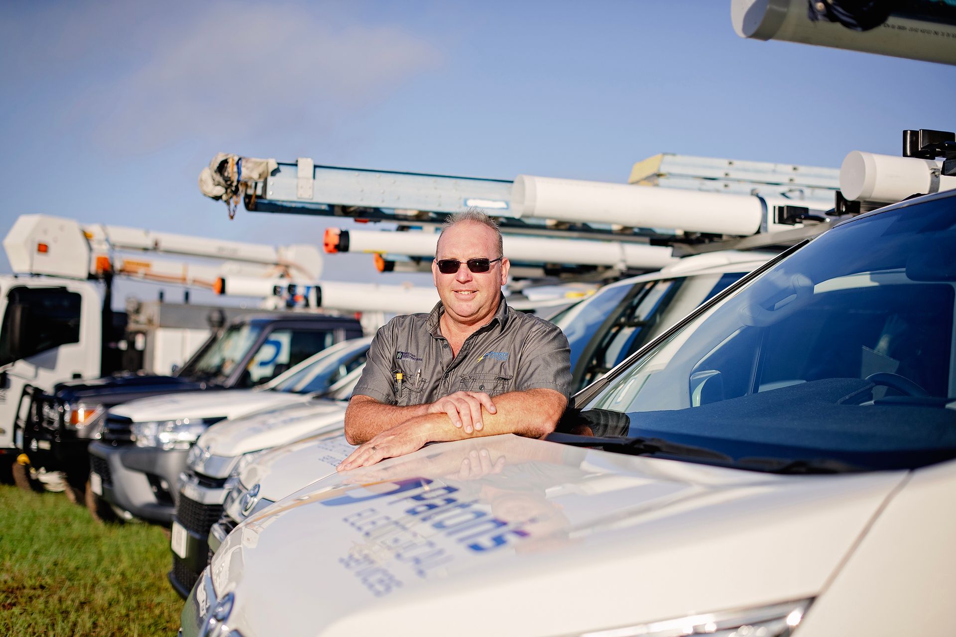 A Man Leaning on Paton's Electrical Truck — Paton's Electrical Services in Urangan, QLD