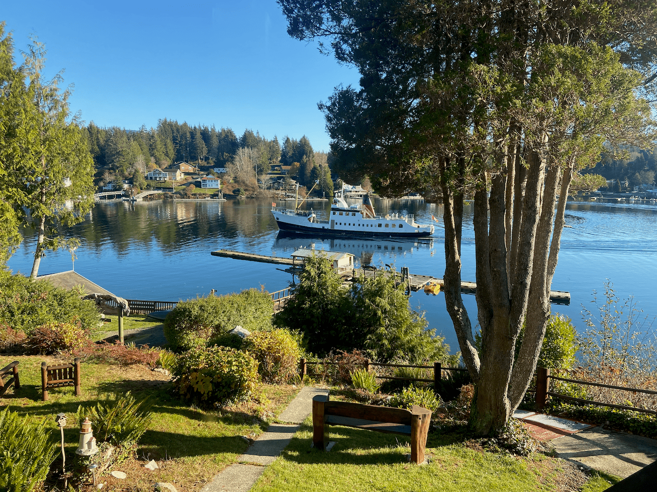 A boat is docked in a body of water surrounded by trees.