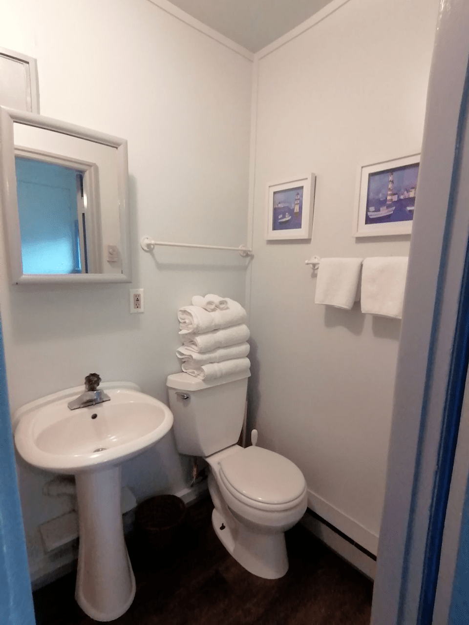 A bathroom with a toilet a sink and a mirror