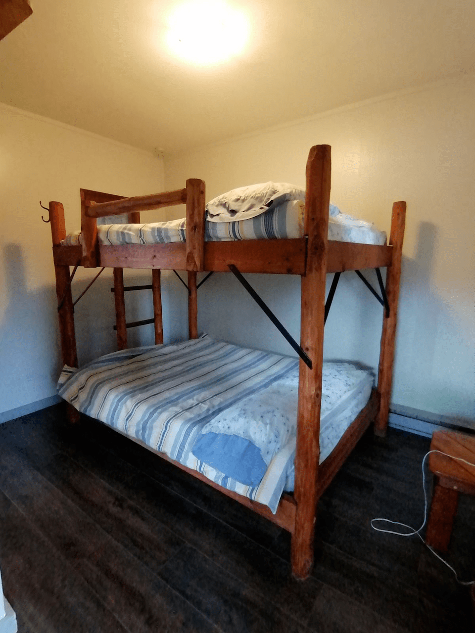A bunk bed in a room with a wooden floor